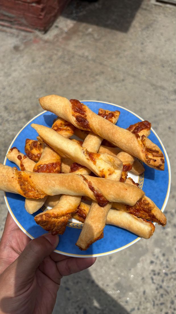 A blue plate of golden cheese twists